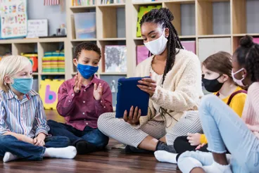 Teacher with ipad and young students