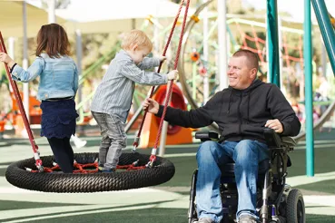 Man in wheelchair with children at the park