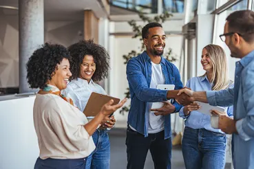 Diverse group of coworkers greeting each other