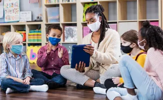 Teacher with iPad and students