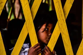 Young girl behind a fence