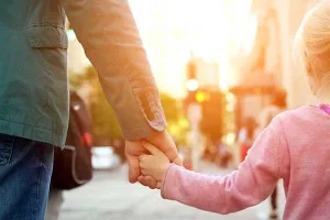 Girl and man holding hands in sunlight