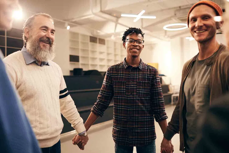 Men holding hands in a support group