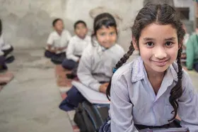 Girls from India sitting in a row in a classroom