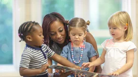 Black teacher with three preK students
