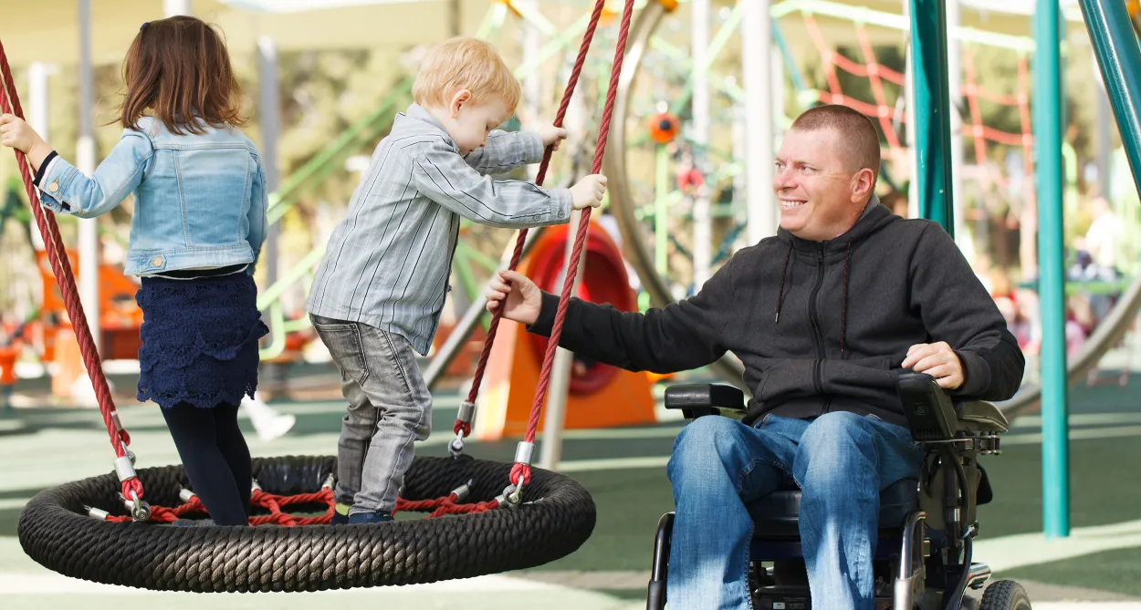Man in wheelchair with children at the park