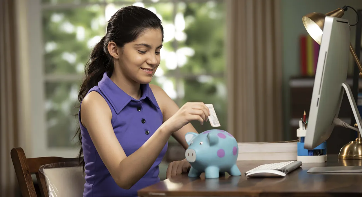 Girl putting money in piggybank