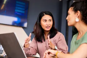 Two female colleagues discussing their work