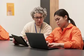 Teacher working with young woman in prison