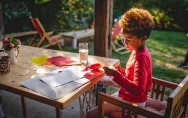 Image of elementary age child doing crafts outdoors