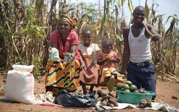 Image of young family in Africa with root vegetables