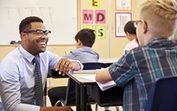 Image of smiling African American teacher with student