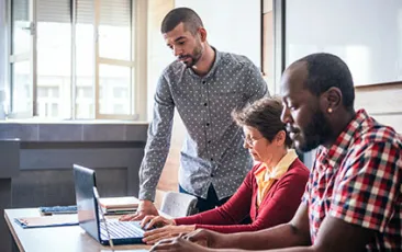 Image of adult students working on laptops