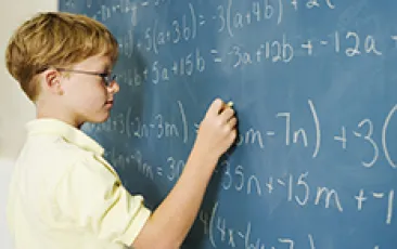 Boy doing math at chalkboard