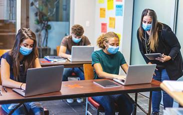 Image of students at computers with masks
