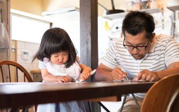 Father and daughter taking a survey at kitchen table