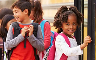 Image of young girl getting onto a school bus