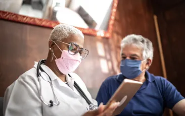 Image of older doctor speaking with patient 
