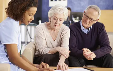 Image of older couple looking at papers with a health professional