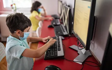 Image of students at computers with social distancing and masks