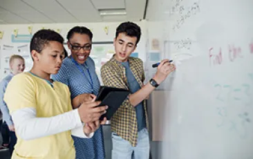 Image of students and teacher at whiteboard