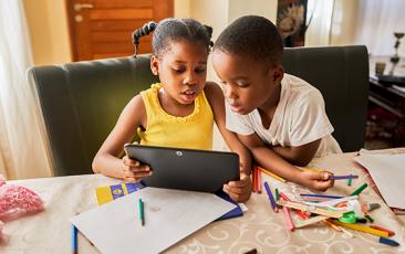 Image of young boy and girl looking at a tablet together 