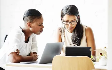 Two women working at laptops