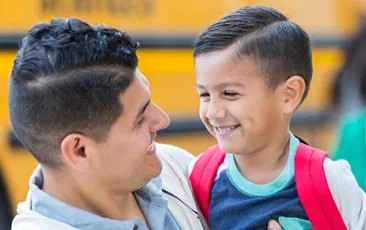 Father and son in front of schoolbus