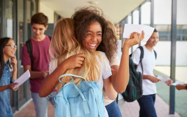 Girls hugging in school hallway