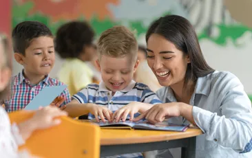 Teacher with happy child reading