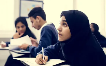 Student in hijab at school desk