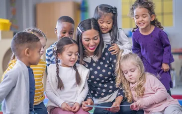 Young students reading with their teacher