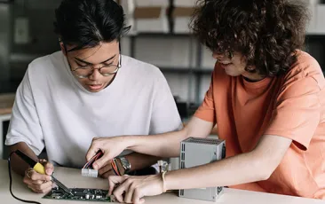 Two high school students working on technical project