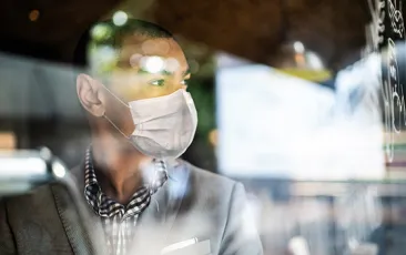 Man in mask looking out the window