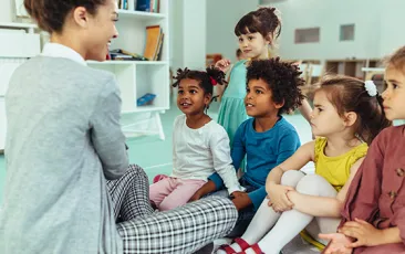 Teacher with young happy diverse students
