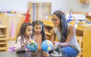 Teacher and two young students working with two globes