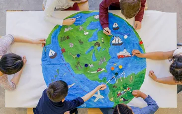Young children painting colorful world map