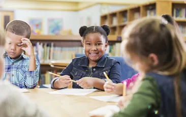 Young elementary students at library table