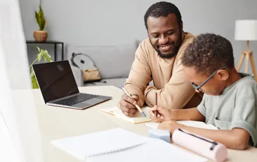 African American Boy Studying with Father at Home