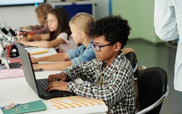 African American student working at a laptop at school