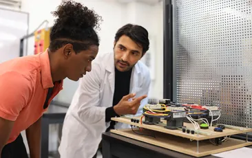 Teacher and student working on an engineering project in a classroom