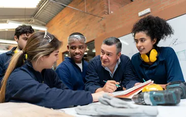 Mentor with apprentices in workshop