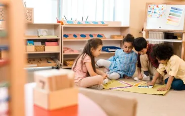 Four children sitting on floor making a color pattern 