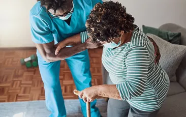 Shot of a young male nurse helping an elderly patient stand