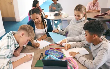 Group of teenagers working on schoolwork at a table