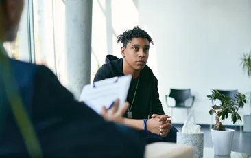 teen boy meeting with adult with clipboard