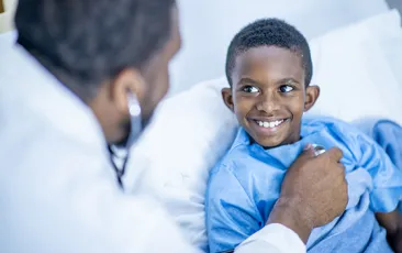 doctor using stethoscope on young patient