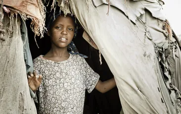 young Somali girl looks out of tent