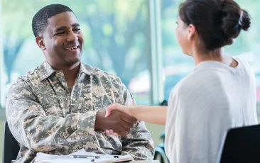 man in military uniform shaking hands