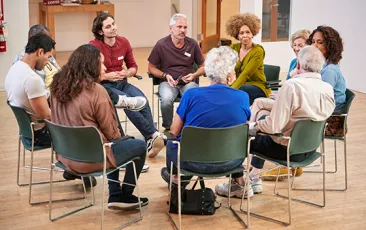 People Attending Self Help Therapy Group Meeting In Community Center